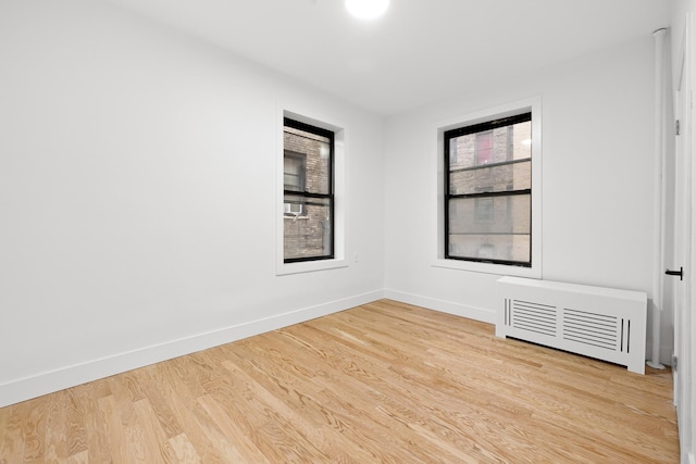 empty room featuring wood finished floors and baseboards