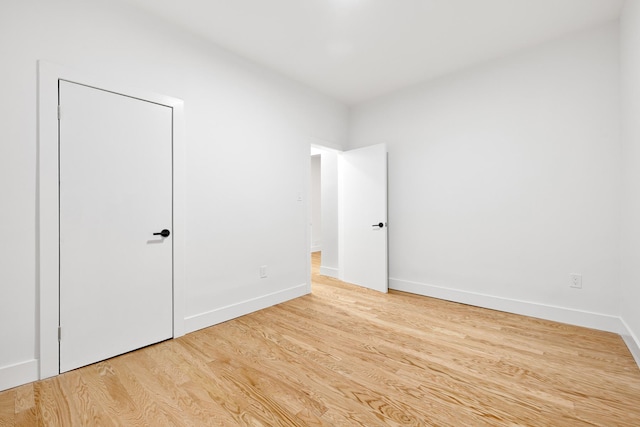 unfurnished bedroom featuring wood finished floors and baseboards