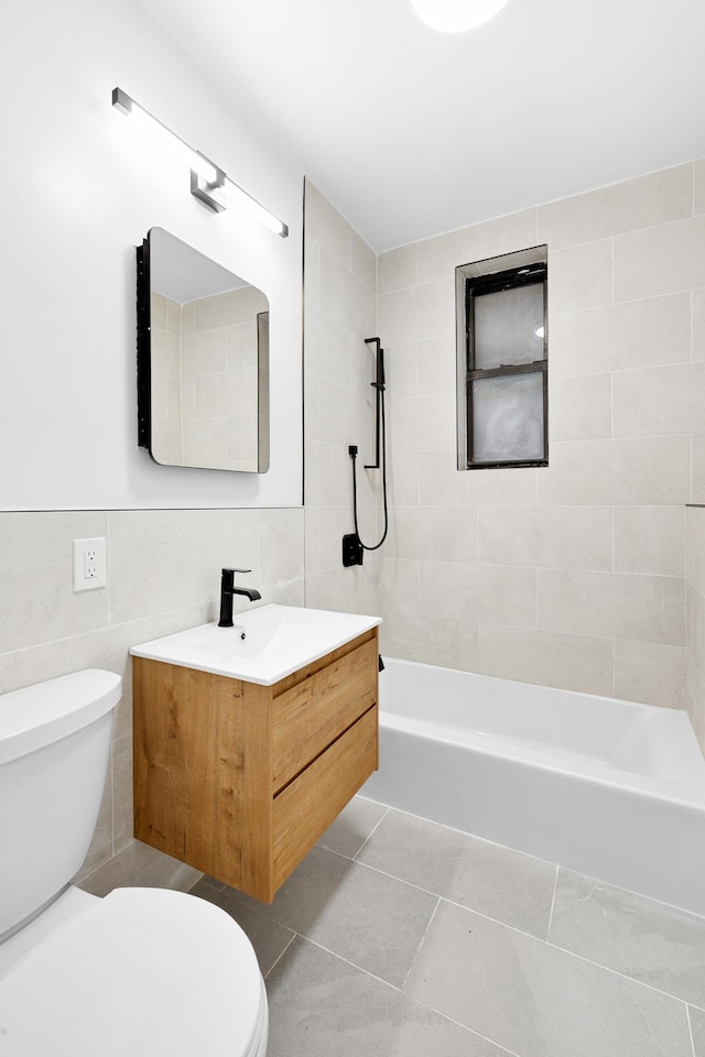 full bath with toilet, tile walls, tub / shower combination, vanity, and tile patterned flooring