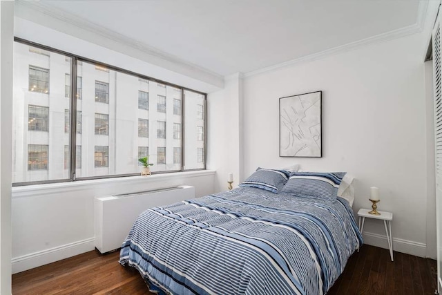 bedroom featuring dark hardwood / wood-style flooring, radiator, and crown molding