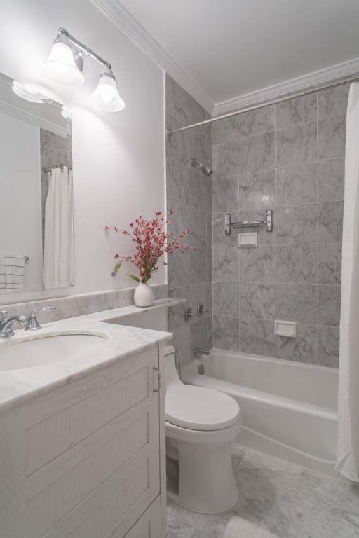 full bathroom featuring shower / tub combo with curtain, ornamental molding, toilet, and vanity