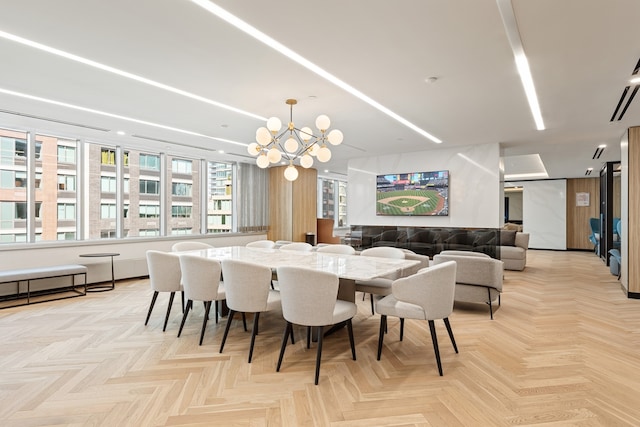 dining room with light parquet flooring and a chandelier