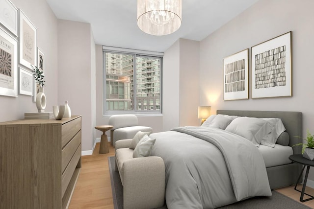 bedroom with a chandelier and light wood-type flooring