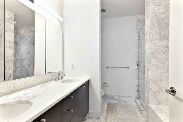 bathroom with vanity, a shower with shower door, and toilet