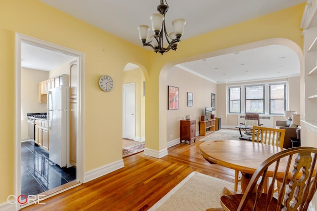 dining space with hardwood / wood-style flooring and an inviting chandelier