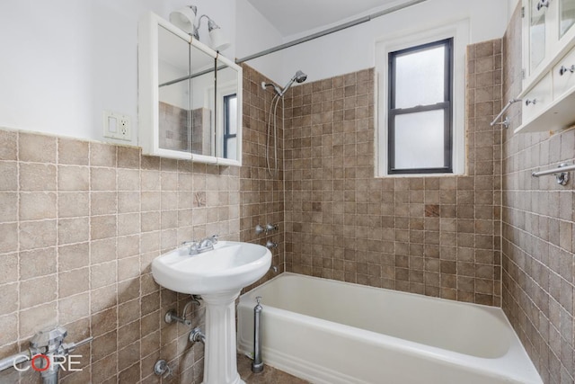 bathroom with tile walls and tiled shower / bath combo