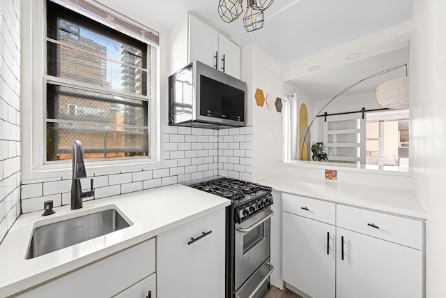 kitchen with a wealth of natural light, appliances with stainless steel finishes, tasteful backsplash, and a sink