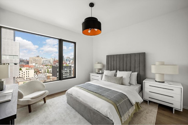 bedroom featuring a city view and wood finished floors