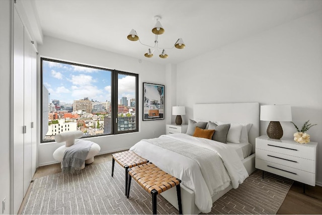 bedroom featuring a view of city and wood finished floors