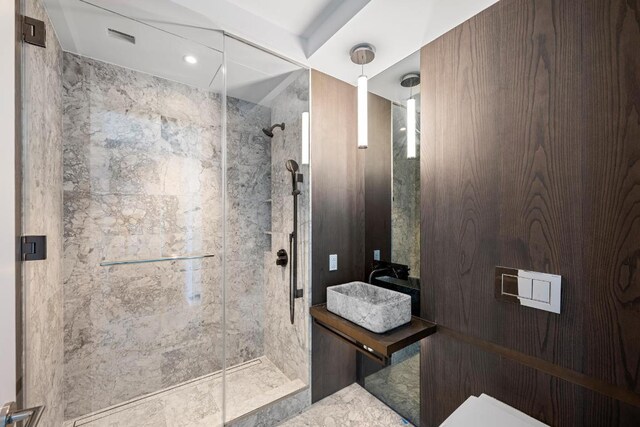 bathroom with vanity, tiled tub, hardwood / wood-style flooring, and tile walls