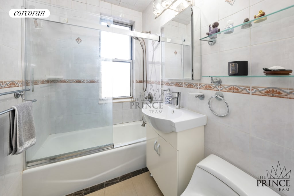 full bathroom with tile walls, tile patterned floors, enclosed tub / shower combo, and toilet