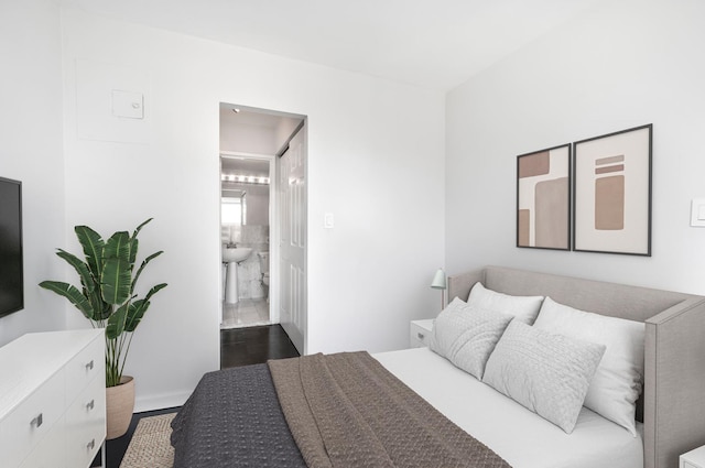 bedroom featuring dark wood-type flooring and ensuite bathroom