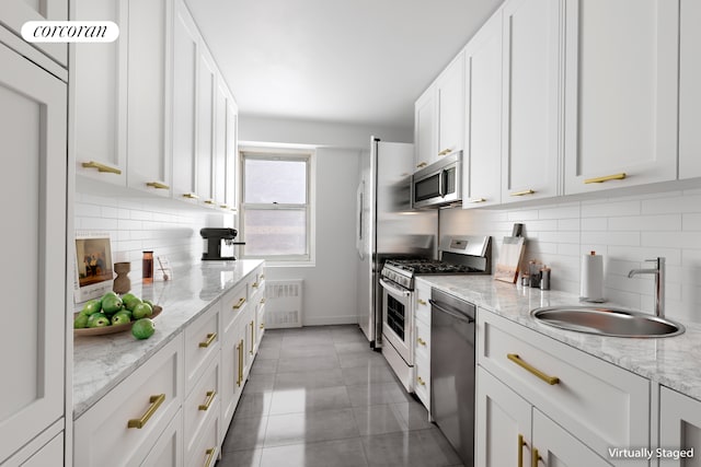 205 E 63rd St Unit 9B, New York City, NY 10065 - kitchen with appliances with stainless steel finishes, radiator heating unit, a sink, white cabinets, and backsplash