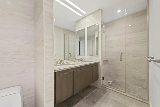 bathroom featuring walk in shower, vanity, tile walls, and toilet