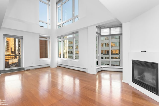 unfurnished living room with hardwood / wood-style floors and a high ceiling