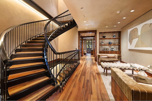 stairway with recessed lighting and wood finished floors