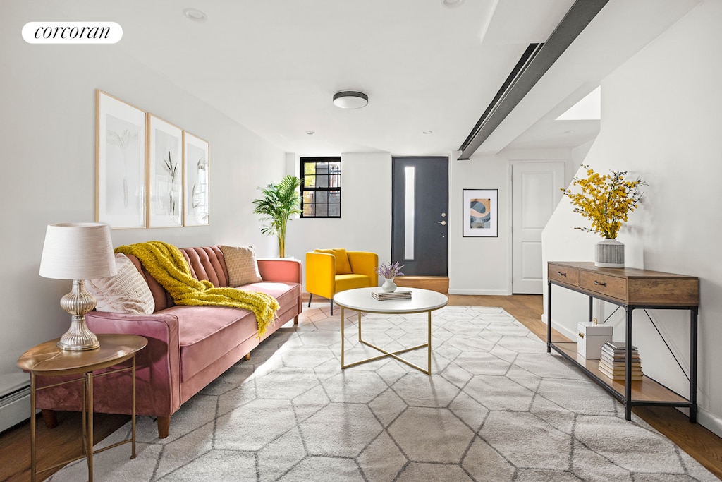 living room featuring wood finished floors, visible vents, and baseboards