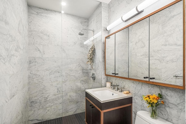 bathroom with tiled shower, toilet, tile walls, and vanity