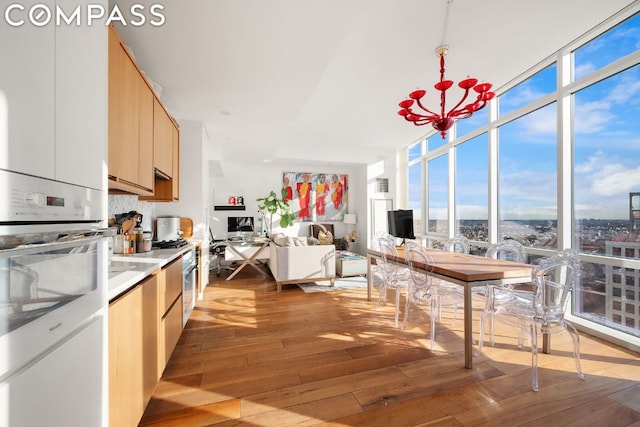 kitchen with refrigerator, light hardwood / wood-style floors, plenty of natural light, and expansive windows