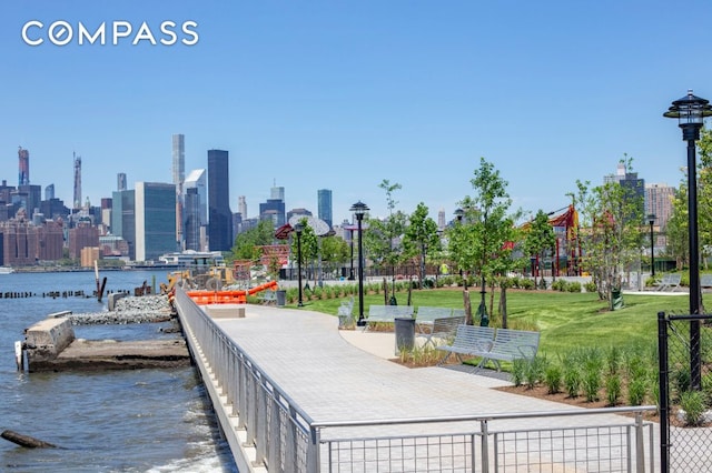 surrounding community featuring a water view, fence, and a city view