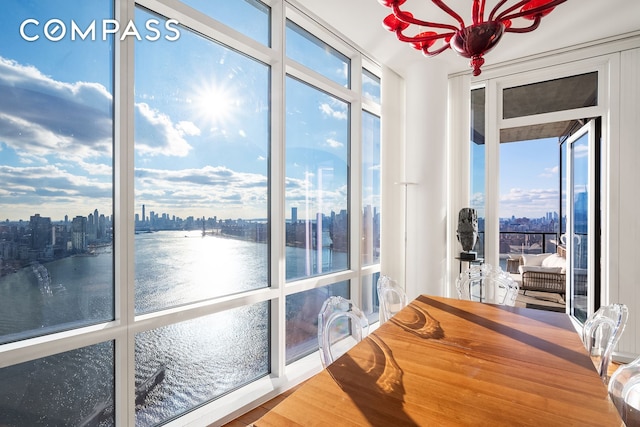 sunroom / solarium featuring a water view and a view of city