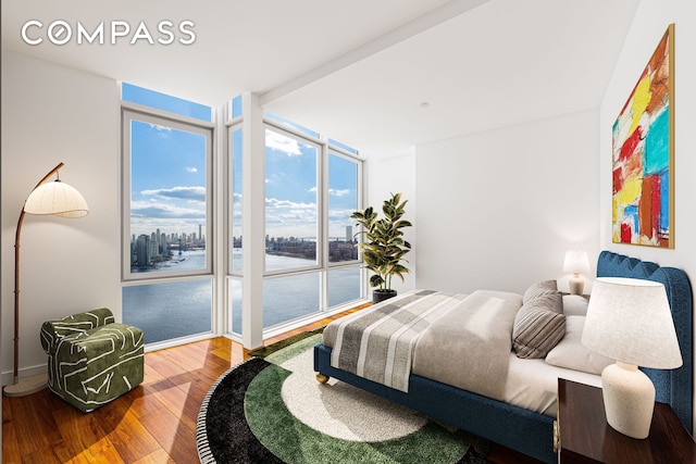 bedroom featuring expansive windows and hardwood / wood-style floors