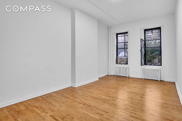 empty room with radiator and light wood-type flooring