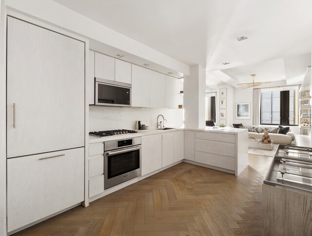 kitchen featuring a sink, white cabinets, appliances with stainless steel finishes, modern cabinets, and open floor plan