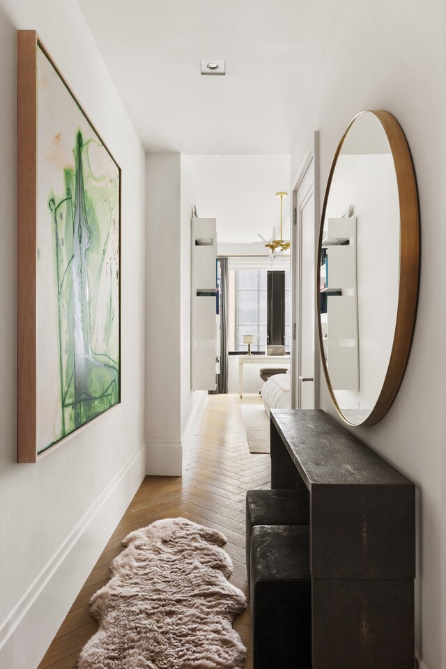 corridor featuring baseboards and wood finished floors