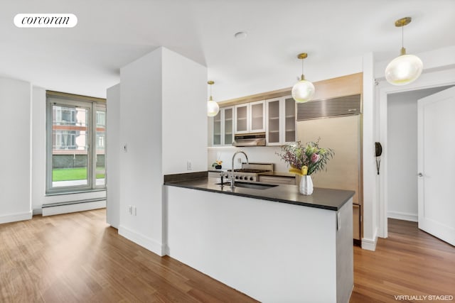 kitchen with dark countertops, a peninsula, visible vents, and a sink