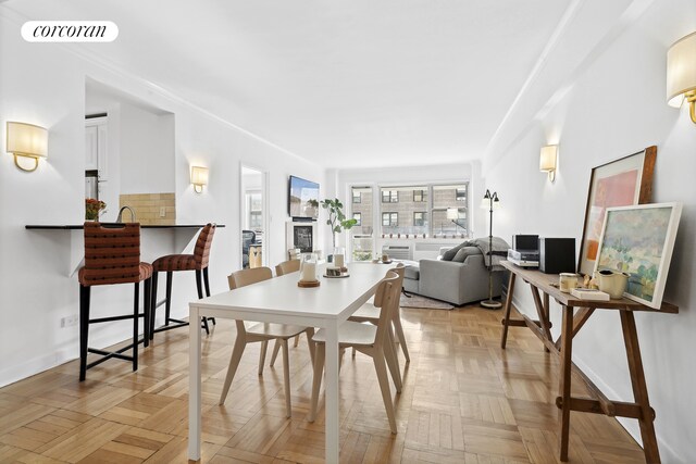 dining room featuring light parquet flooring and crown molding