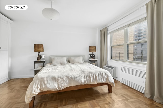 bedroom featuring an AC wall unit and light parquet floors