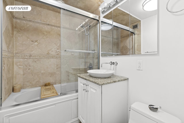 full bathroom with toilet, combined bath / shower with glass door, and vanity