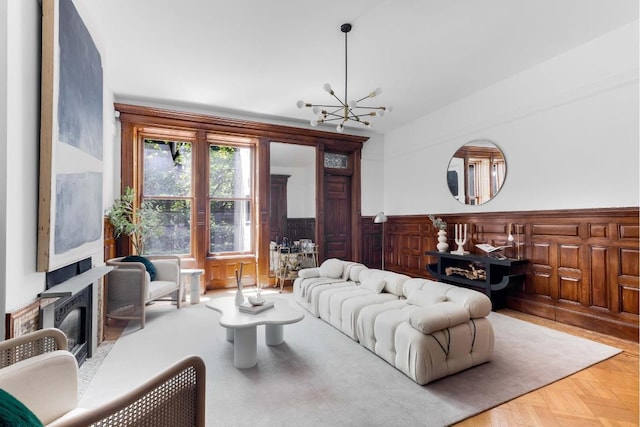 living room featuring parquet floors, a fireplace, and a chandelier