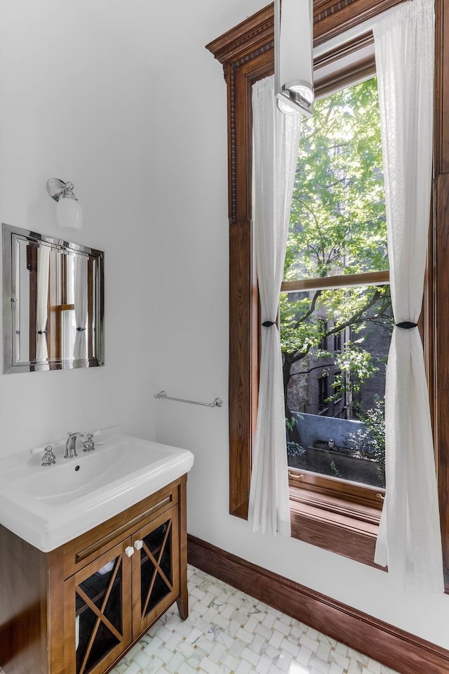 bathroom with tile patterned floors, baseboards, and vanity