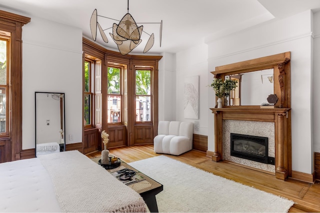 interior space with light wood-style floors, a notable chandelier, and a glass covered fireplace