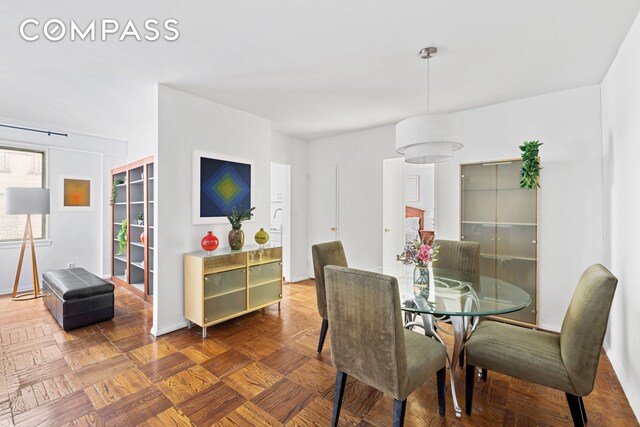 dining space with parquet flooring