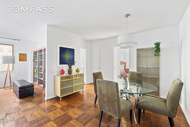 dining space with parquet flooring