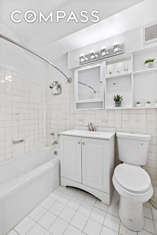 full bathroom featuring vanity, tiled shower / bath, toilet, and tile patterned floors