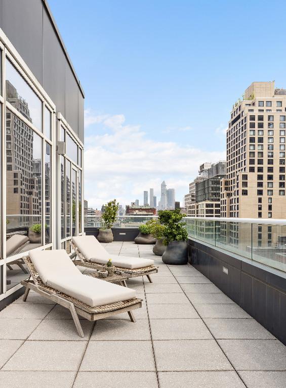 view of patio with a balcony and a city view