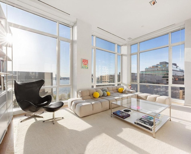 sunroom / solarium featuring a healthy amount of sunlight, a water view, and a view of city