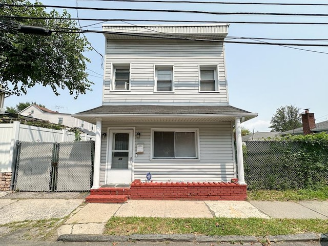 view of front facade with covered porch, fence, and a gate