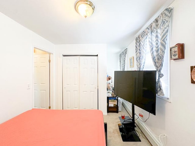 bedroom featuring a closet, light carpet, and baseboards