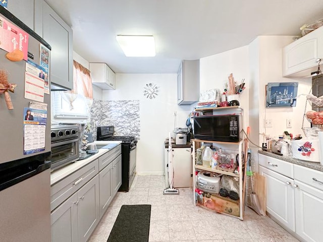 kitchen featuring black appliances, decorative backsplash, light countertops, and a toaster