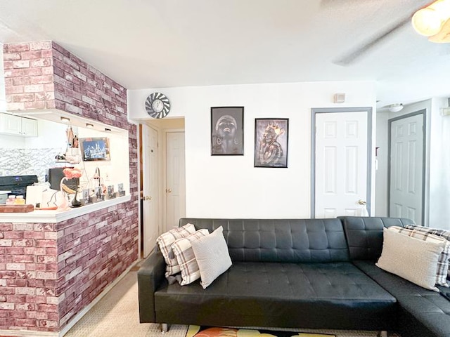 living area featuring carpet floors and brick wall