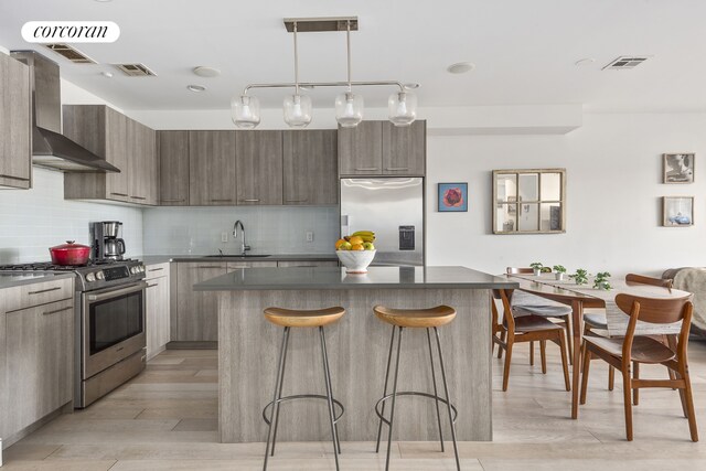 kitchen with sink, decorative light fixtures, stainless steel appliances, and backsplash