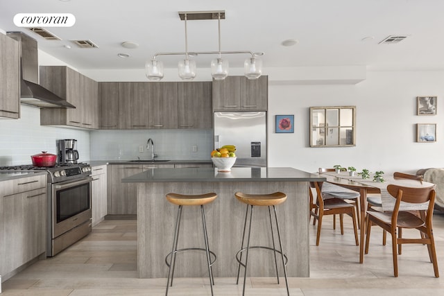 kitchen with stainless steel appliances, a sink, a kitchen bar, modern cabinets, and a kitchen island