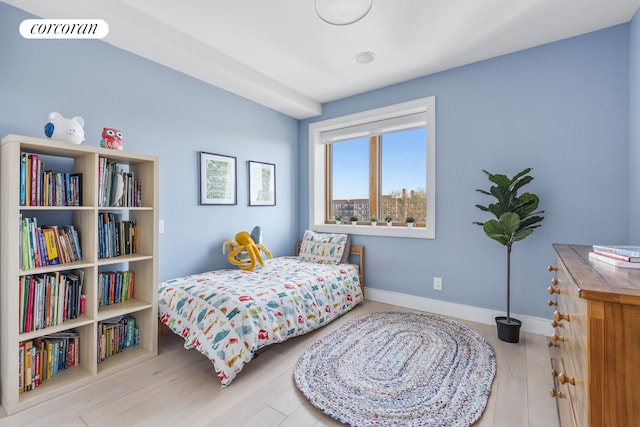 bedroom featuring baseboards, wood finished floors, and visible vents