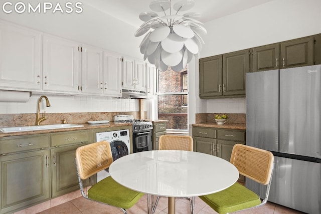 kitchen with backsplash, sink, light tile patterned floors, appliances with stainless steel finishes, and white cabinets