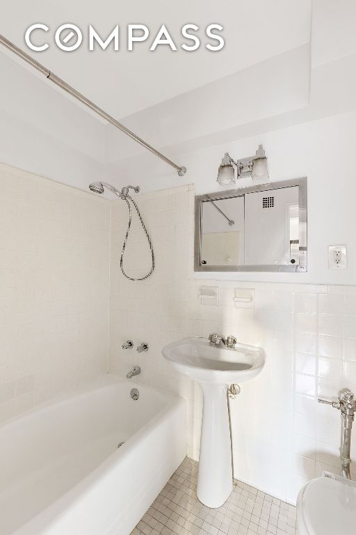 full bathroom featuring shower / washtub combination, tile walls, and toilet